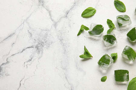 Ice cubes and fresh mint leaves on light backgroundの写真素材