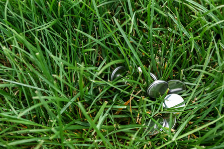 Lithium button cell batteries on green grass outdoors