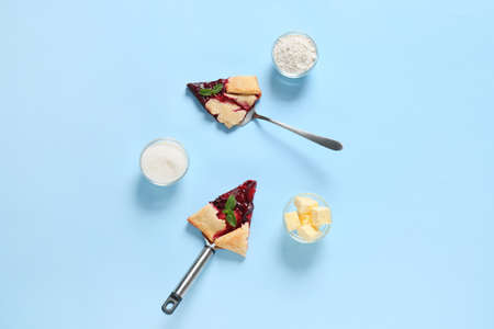 Composition with pieces of fresh plum galette, butter, sugar and flour on color backgroundの写真素材