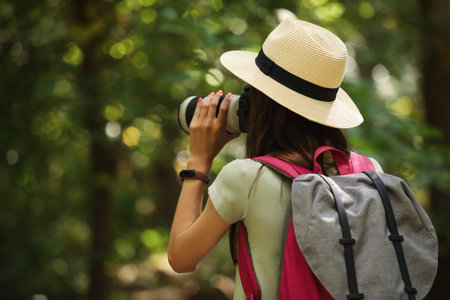 Female tourist with modern photo camera in park