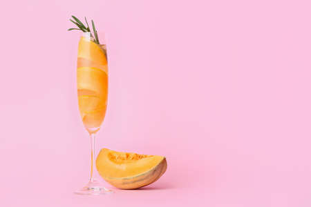 Glass of cold melon cocktail on pink backgroundの写真素材