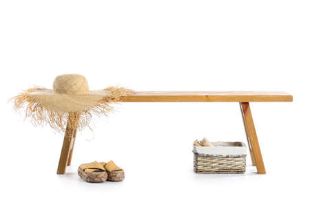 Wooden bench with straw hat, shoes and basket on white backgroundの写真素材