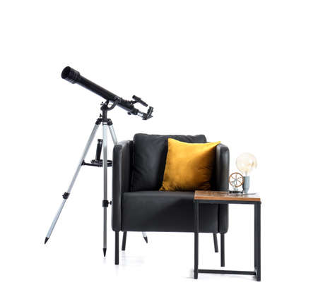 Black armchair with pillow, table and modern telescope on white backgroundの写真素材