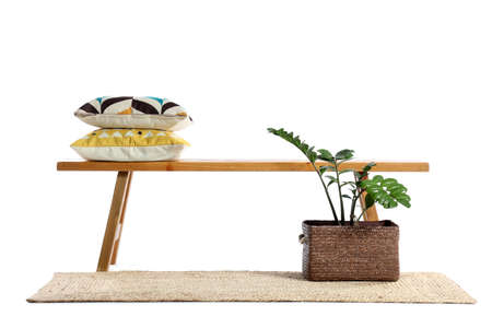 Wooden bench with pillows, houseplant and rug on white backgroundの写真素材