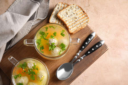Pots with tasty meatball soup and bread on color backgroundの写真素材