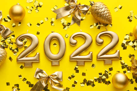 Figure 2022 and Christmas decor on yellow background