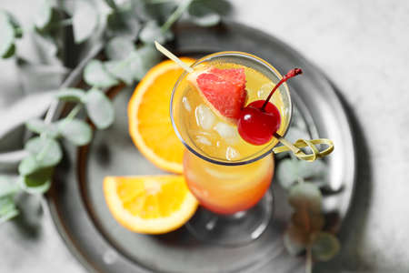 Glass of tasty Tequila Sunrise cocktail on tableの写真素材