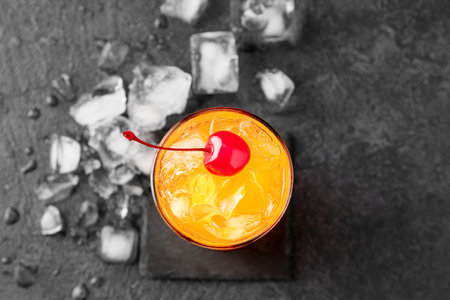 Glass of tasty Tequila Sunrise cocktail on dark backgroundの写真素材