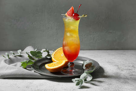 Glass of tasty Tequila Sunrise cocktail on tableの写真素材