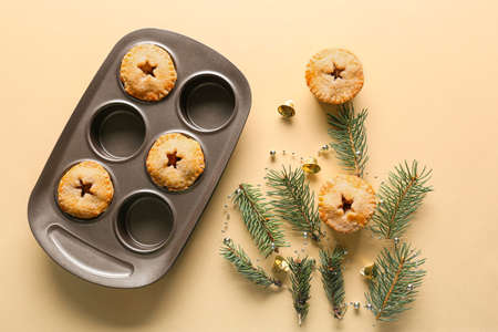 Baking tray with tasty mince pies on color backgroundの写真素材