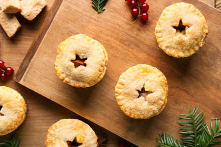 Tasty mince pies on wooden background