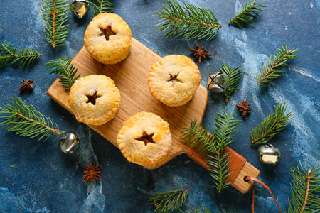 Board with tasty mince pies and Christmas decor on color backgroundの写真素材