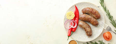 Plate with tasty grilled sausages and vegetables on white background with space for textの写真素材