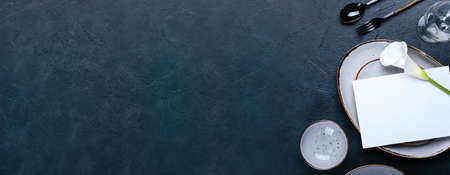 Beautiful table setting with calla lily on dark background. Banner design