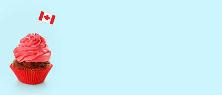 Delicious cupcake with flag of Canada on light blue background with space for text