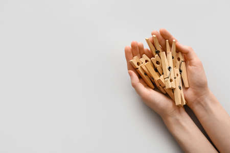 Woman holding clothes pins on gray backgroundの写真素材