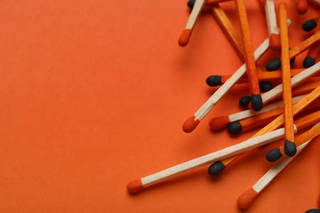 Different new matchsticks on orange background, closeup