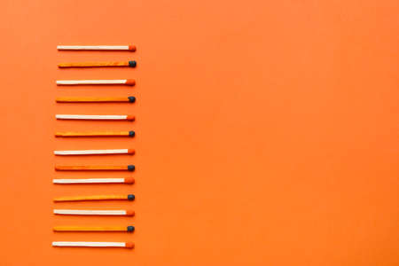 Different new matchsticks on orange backgroundの写真素材