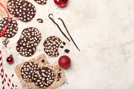 Tasty cookies with white chocolate chips and Christmas balls on light backgroundの写真素材