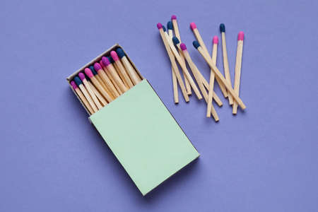 Box with different new matchsticks on purple backgroundの写真素材