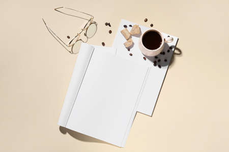 Blank magazine with cup of coffee and eyeglasses on light backgroundの写真素材