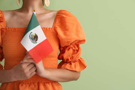 Young woman with Mexican flag on green background, closeupの写真素材