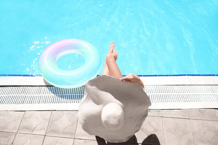 Young woman with inflatable ring near swimming poolの写真素材