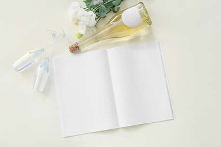 Blank magazine with champagne and flowers on white background