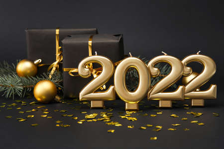 Figure 2022 with gift boxes and confetti on black background