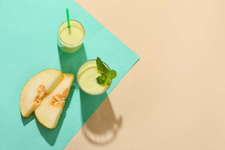 Glasses of tasty melon milkshake on color backgroundの写真素材
