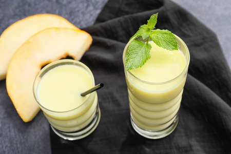 Glasses of tasty melon milkshake on dark background, closeupの写真素材