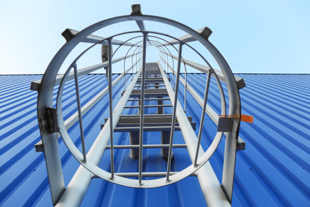 Fire escape metal ladder of blue building outdoors, closeupの写真素材