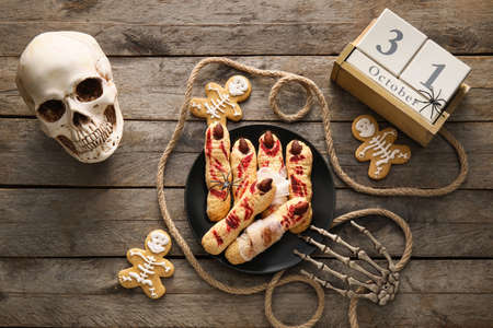 Plate with tasty cookies for Halloween celebration and decor on wooden backgroundの写真素材