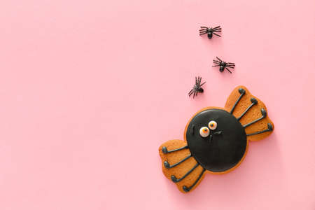 Tasty cookie for Halloween celebration on color background