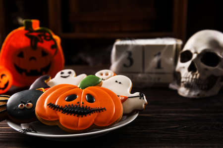 Plate with tasty cookies for Halloween celebration on tableの写真素材