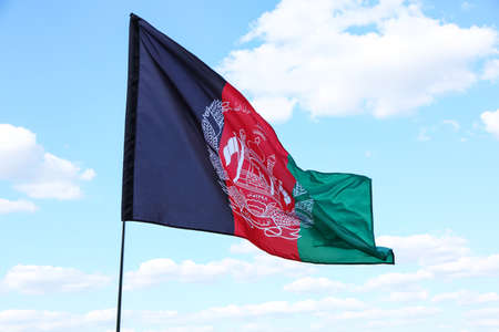 Waving Afghanistan flag against blue skyの写真素材