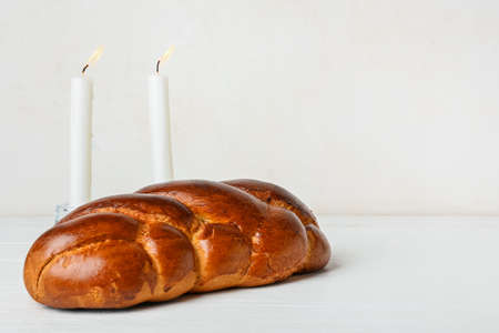 Traditional challah bread with glowing candles on white background. Shabbat Shalomの写真素材