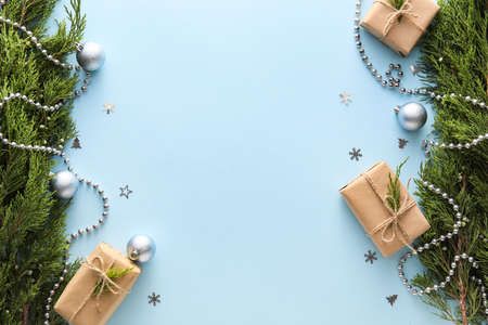 Coniferous branches, gift boxes and Christmas decorations on blue background