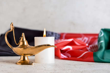 Muslim lamp, burning candle and flag of Afghanistan on tableの写真素材