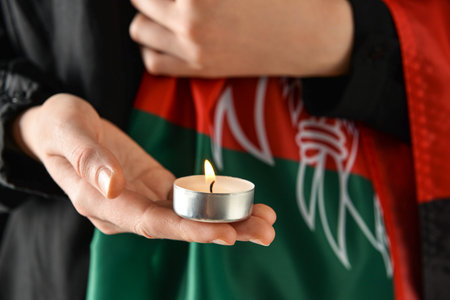 Woman with flag of Afghanistan and candle, closeupの写真素材