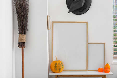 Table with blank frames in room decorated for Halloween