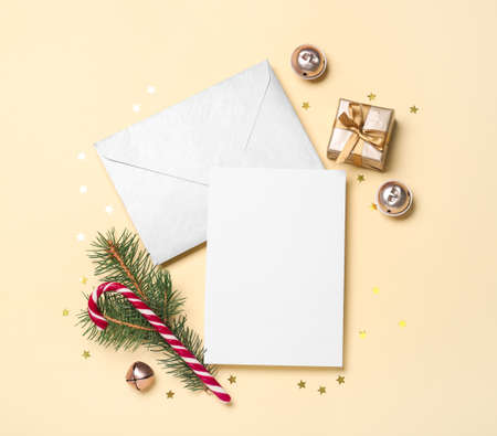 Christmas composition with candy canes and letter with greeting card on beige background