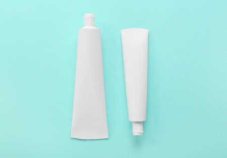 Tubes with toothpaste on color background