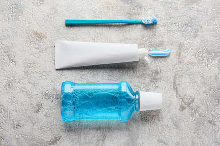 Tube with toothpaste, brush and mouthwash on gray backgroundの写真素材