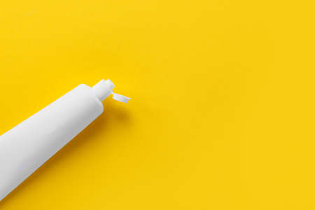 Tube with toothpaste on yellow backgroundの写真素材
