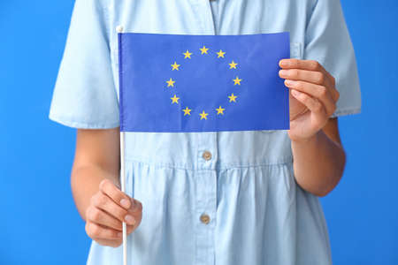 Young woman with flag of European Union on color backgroundの写真素材