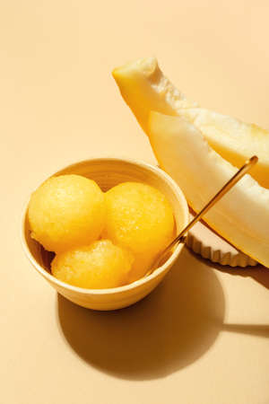 Bowl with tasty melon sorbet on beige backgroundの写真素材