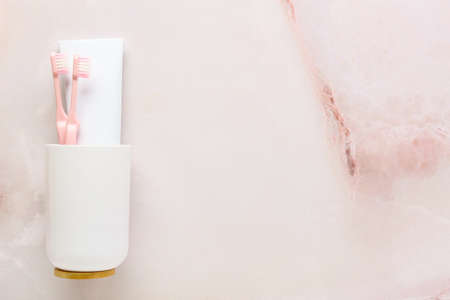 Holder with toothpaste and brushes on light background