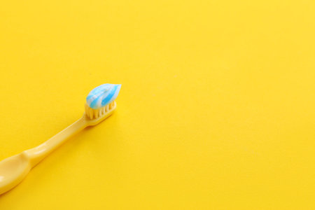 Tooth brush with paste on yellow backgroundの写真素材