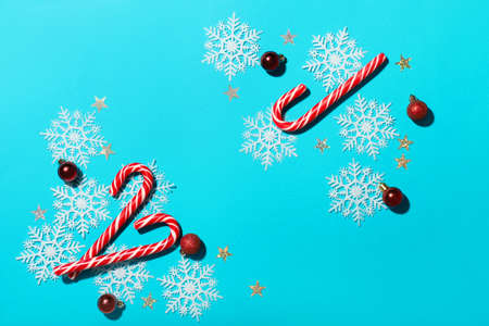 Composition with candy canes and decorations on color background